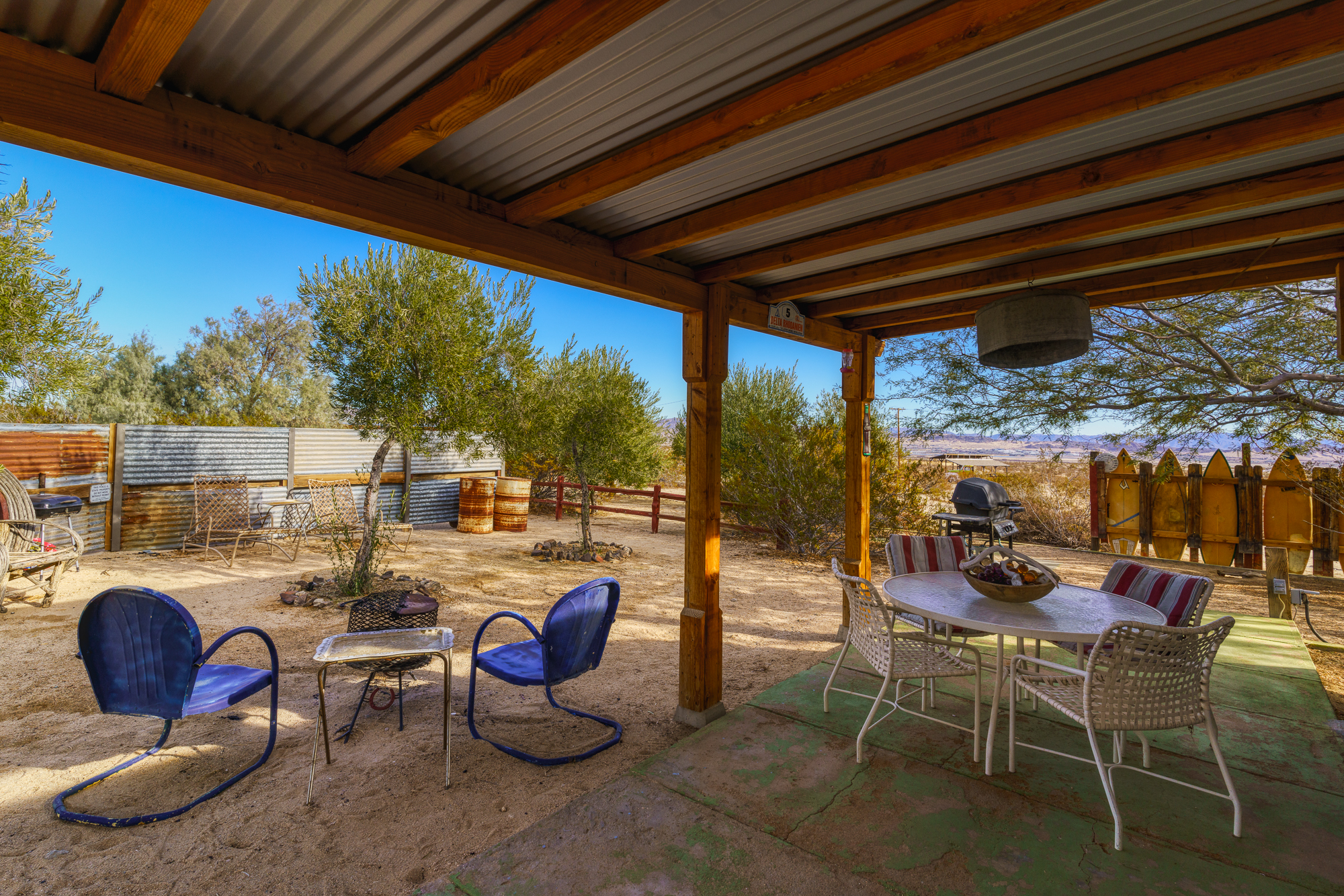 Patio of the vacation rental containing a large round table with four seats to lounge at.