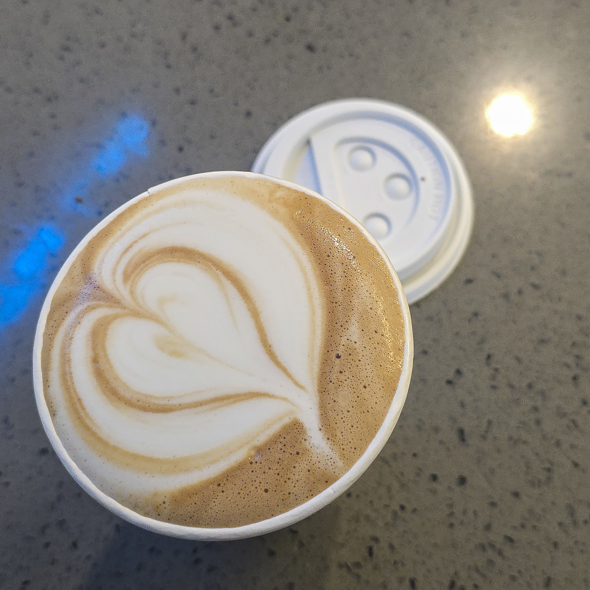 Mocha Coffee Topped with Heart-shaped Latte Art in a White To-go Cup on a Café Counter at Bliss Cafe in Joshua Tree.